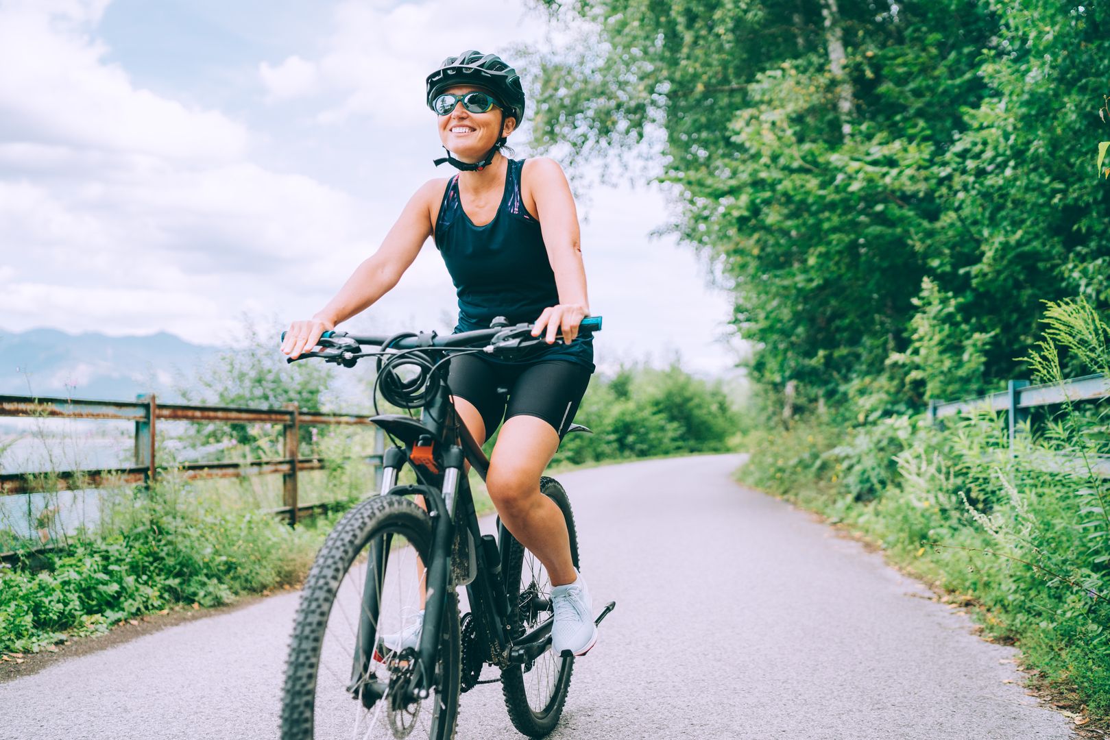 Eine Frau in Sportkleidung und Fahrradhelm, die E-Bike fährt